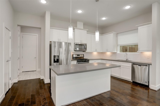 kitchen with stainless steel appliances, backsplash, a sink, and white cabinets