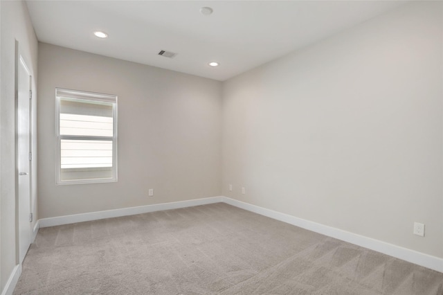 unfurnished room with recessed lighting, light colored carpet, visible vents, and baseboards