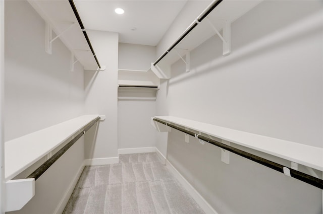 spacious closet featuring light colored carpet