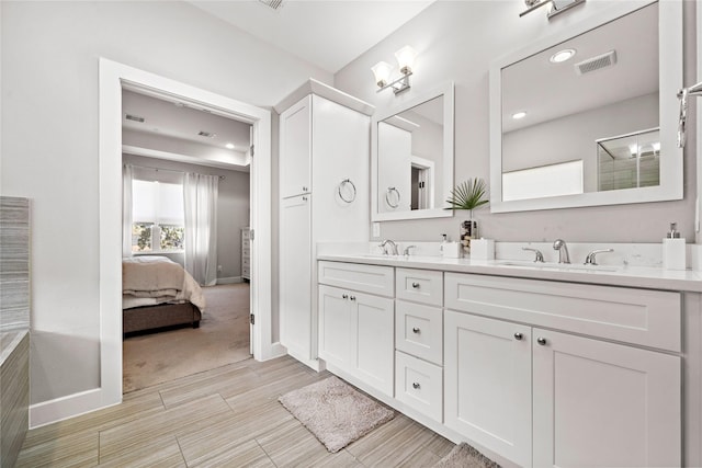 full bathroom with visible vents, a sink, baseboards, and double vanity