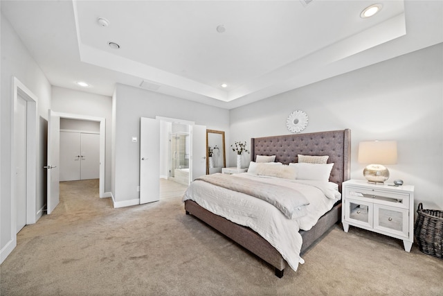 bedroom featuring connected bathroom, recessed lighting, light colored carpet, baseboards, and a tray ceiling