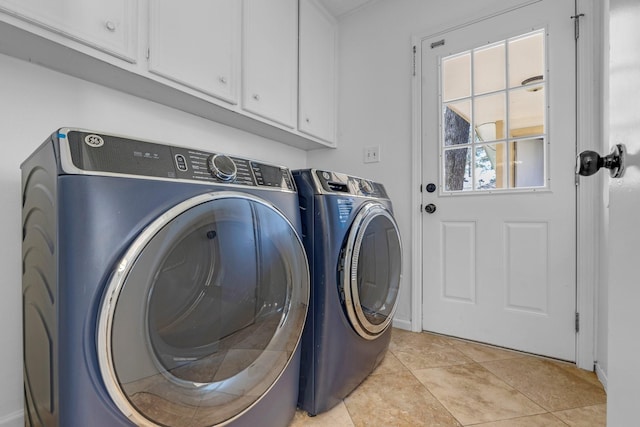 clothes washing area with light tile patterned floors, independent washer and dryer, and cabinet space