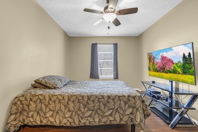 bedroom featuring ceiling fan, a textured ceiling, and wood finished floors