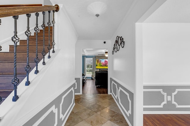 hall featuring ornamental molding, stairway, and baseboards