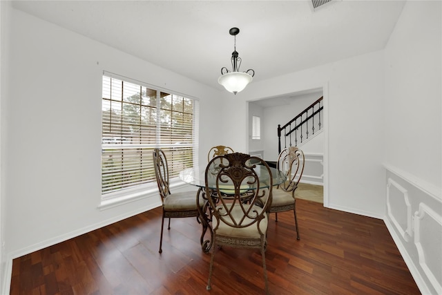 dining space with stairs, baseboards, and wood finished floors