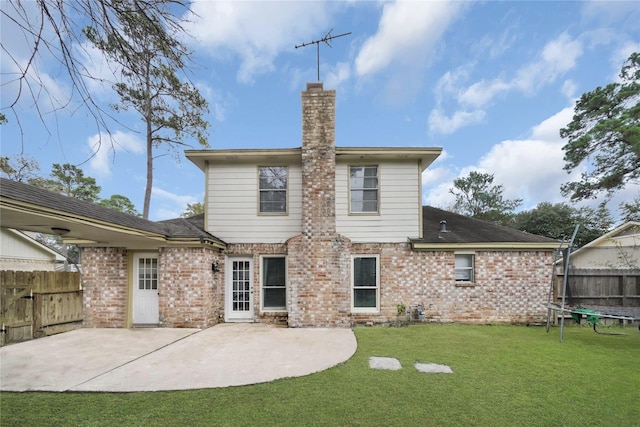 rear view of house featuring a patio, fence, a lawn, and brick siding