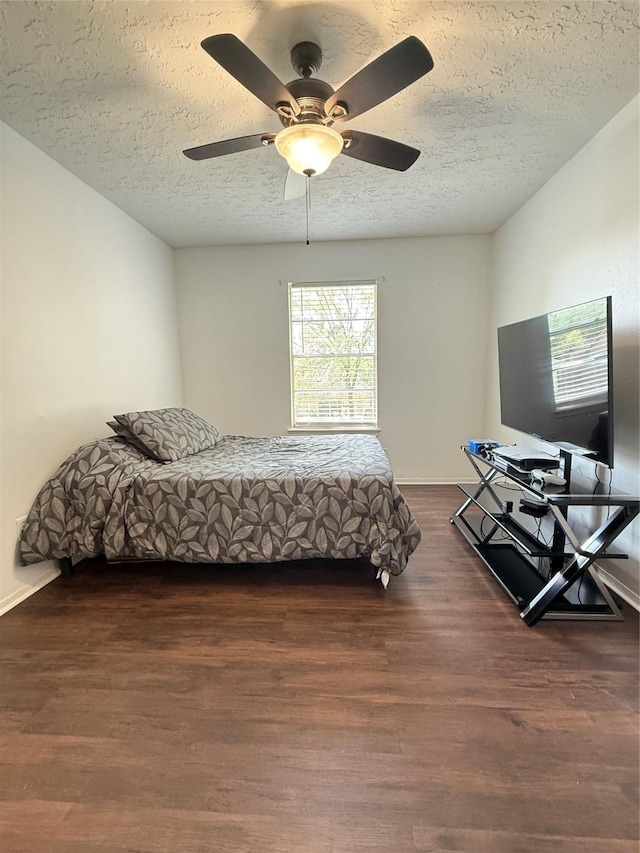 15523 Canterbury Forest Dr, Tomball, TX 77377 - bedroom featuring a textured ceiling, dark wood-style flooring, a ceiling fan, and baseboards