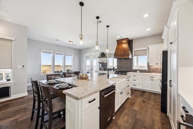 kitchen featuring decorative backsplash, dark wood-type flooring, visible vents, and premium range hood