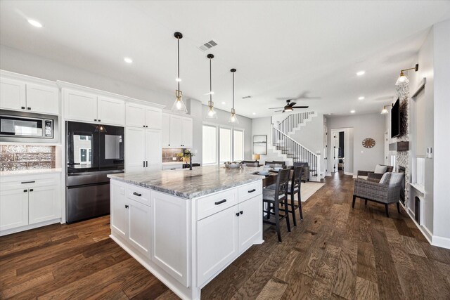 kitchen with visible vents, appliances with stainless steel finishes, white cabinetry, and dark wood-type flooring