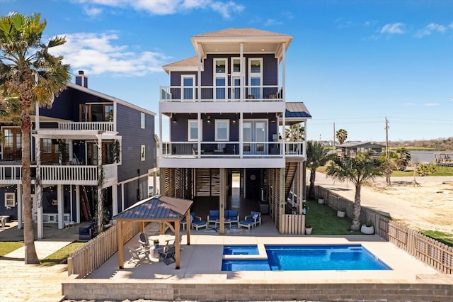 rear view of property with a patio, a fenced backyard, stairway, a fenced in pool, and a balcony