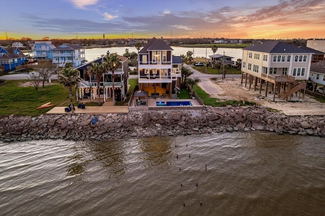 aerial view at dusk with a residential view and a water view