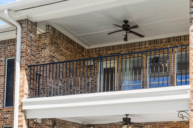 interior space featuring ceiling fan and brick siding