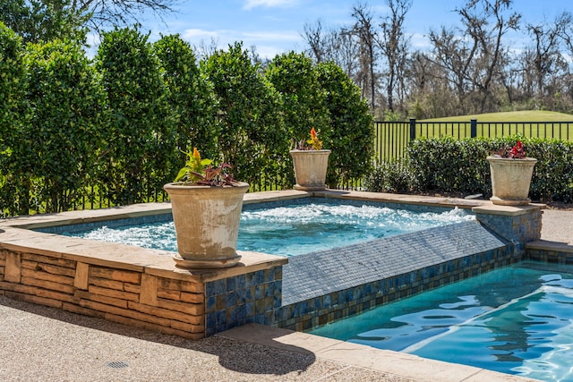 view of pool featuring fence and an in ground hot tub