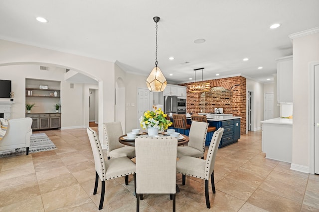 dining space featuring built in shelves, arched walkways, recessed lighting, visible vents, and ornamental molding