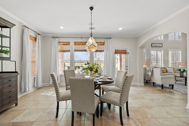 dining room with arched walkways, visible vents, crown molding, and baseboards