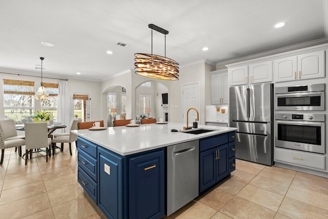 kitchen featuring arched walkways, stainless steel appliances, a sink, white cabinetry, and blue cabinetry