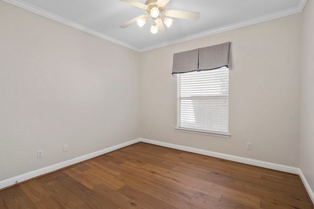 empty room featuring ornamental molding, baseboards, and wood finished floors