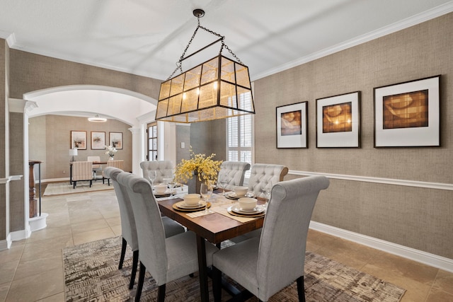 dining room featuring arched walkways, light tile patterned floors, baseboards, and wallpapered walls