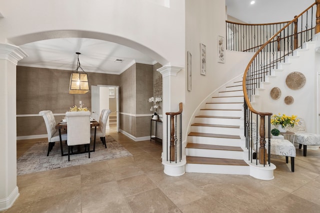 dining space with a towering ceiling, ornate columns, baseboards, and arched walkways