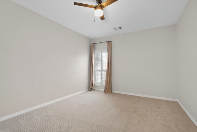 empty room featuring light carpet, baseboards, visible vents, and a ceiling fan