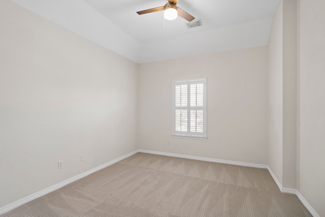 spare room with light carpet, a ceiling fan, visible vents, and baseboards