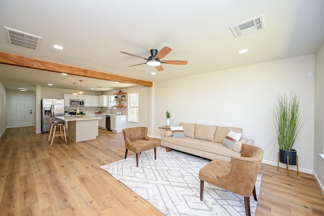 living area with visible vents, recessed lighting, light wood-type flooring, and baseboards