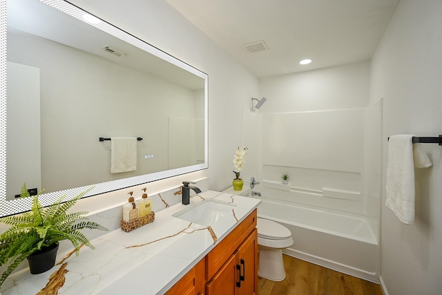 full bathroom with visible vents, toilet, wood finished floors, shower / bathing tub combination, and vanity