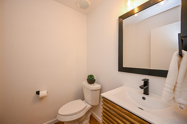 bathroom with baseboards, toilet, and vanity