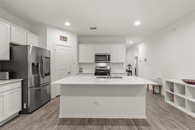 kitchen with stainless steel appliances, visible vents, a sink, and white cabinetry