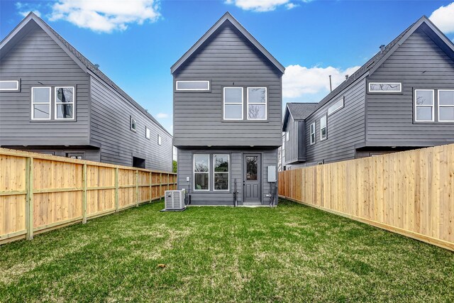 back of house with a yard, central AC unit, and a fenced backyard