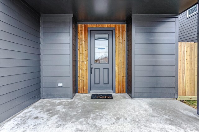 doorway to property featuring fence