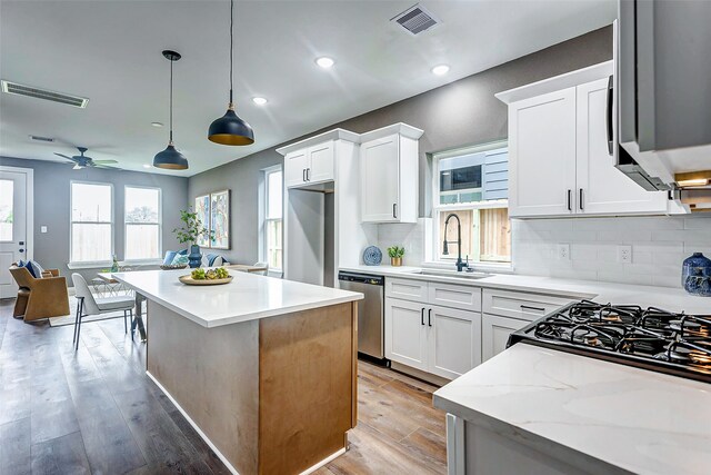 kitchen with backsplash, visible vents, stainless steel appliances, and a sink