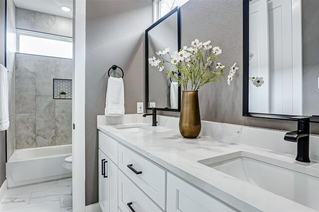 full bathroom with marble finish floor, a sink, toilet, and double vanity