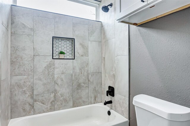 full bath featuring a textured wall, tub / shower combination, and toilet