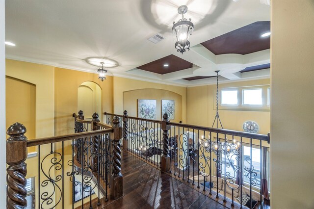 hallway featuring an upstairs landing, coffered ceiling, crown molding, and wood finished floors