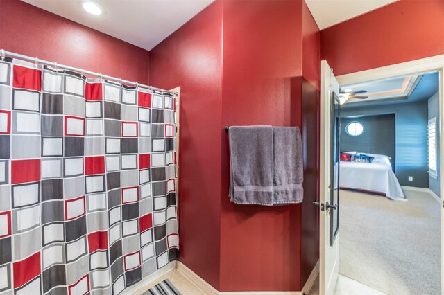 full bath with ensuite bathroom, a shower with shower curtain, and baseboards