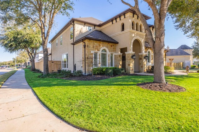 view of front of home with stone siding, stucco siding, and a front yard