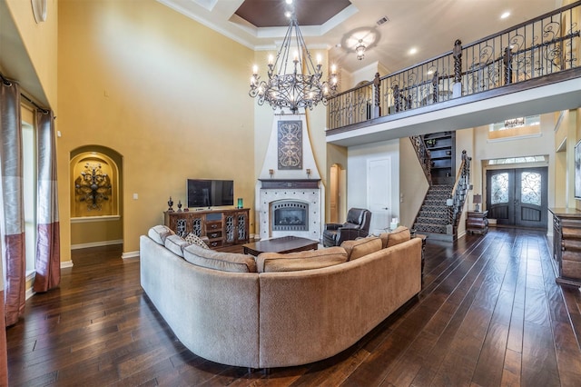 living area with dark wood finished floors, stairs, french doors, a high ceiling, and arched walkways