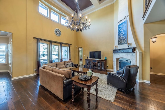 living room featuring arched walkways, ornamental molding, baseboards, and dark wood-style flooring