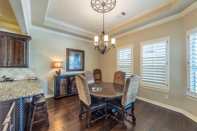 dining space featuring dark wood-style floors, visible vents, baseboards, a raised ceiling, and a chandelier