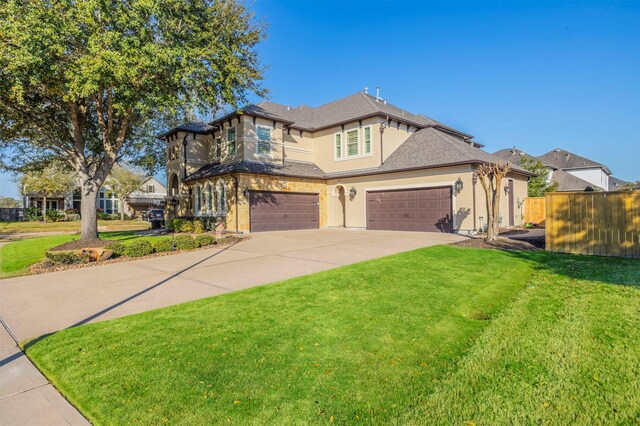 view of front of house featuring stucco siding, driveway, a front yard, and fence