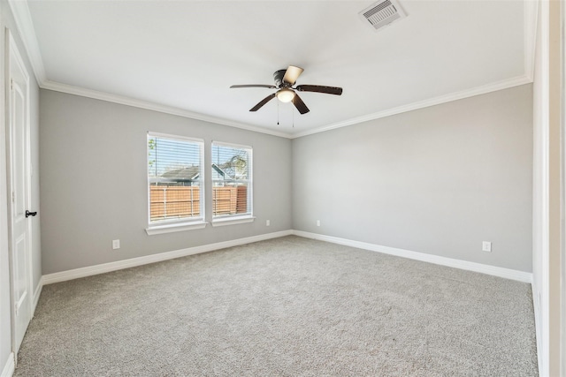 spare room with ornamental molding, carpet flooring, visible vents, and baseboards