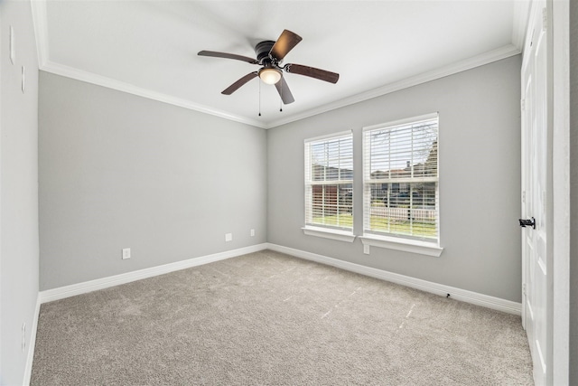 carpeted empty room featuring ceiling fan, ornamental molding, and baseboards