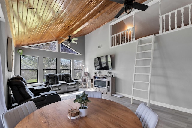 dining area featuring a fireplace, wood finished floors, wooden ceiling, and baseboards