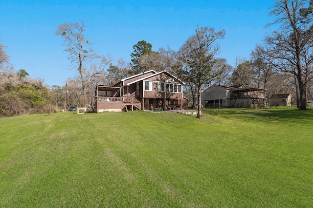 back of house with a sunroom, a lawn, and a deck