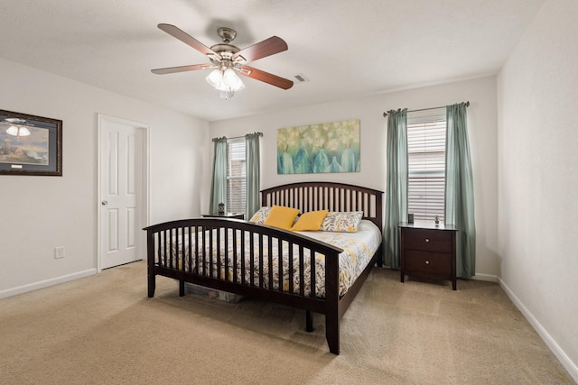 bedroom featuring light carpet, ceiling fan, visible vents, and baseboards