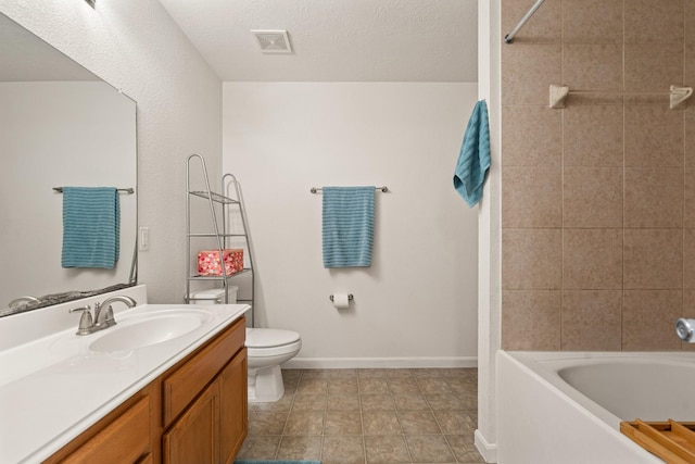 full bath featuring visible vents, toilet, vanity, a textured ceiling, and baseboards