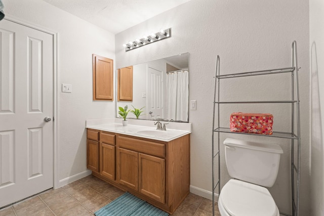 bathroom with baseboards, vanity, toilet, and tile patterned floors