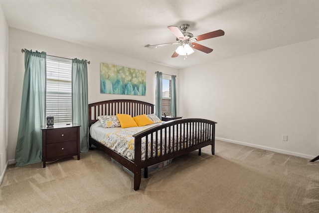 bedroom featuring baseboards, a ceiling fan, and light colored carpet