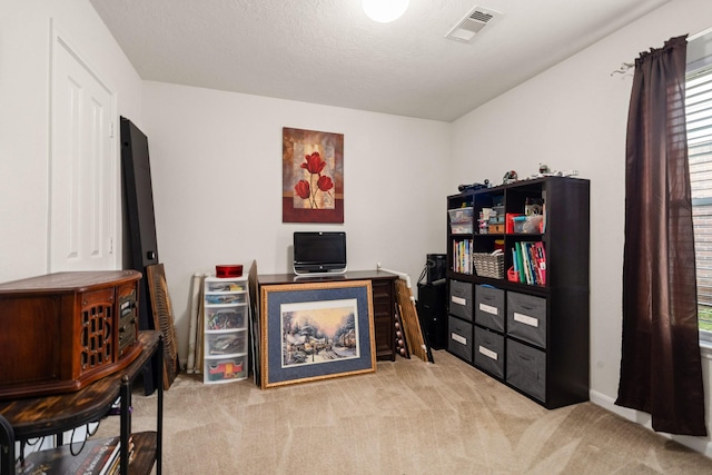 home office featuring a textured ceiling, carpet, and visible vents